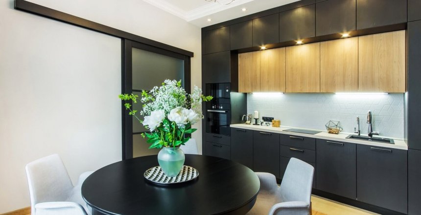 Beautiful kitchen in contemporary apartment. Modern interior 
with round breakfast table with flowers and sliding door